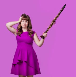 photo of Kari Landry holding a clarinet like a pointer