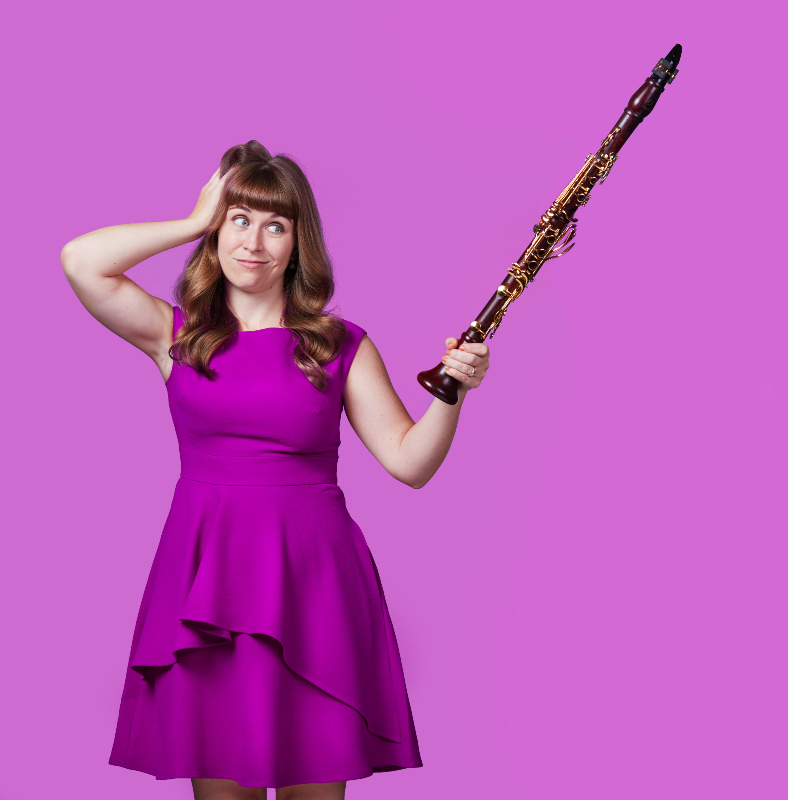 photo of Kari Landry holding a clarinet like a pointer